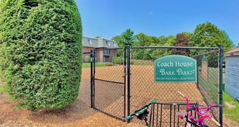 A playground with a gate and a sign for coach house and bark park